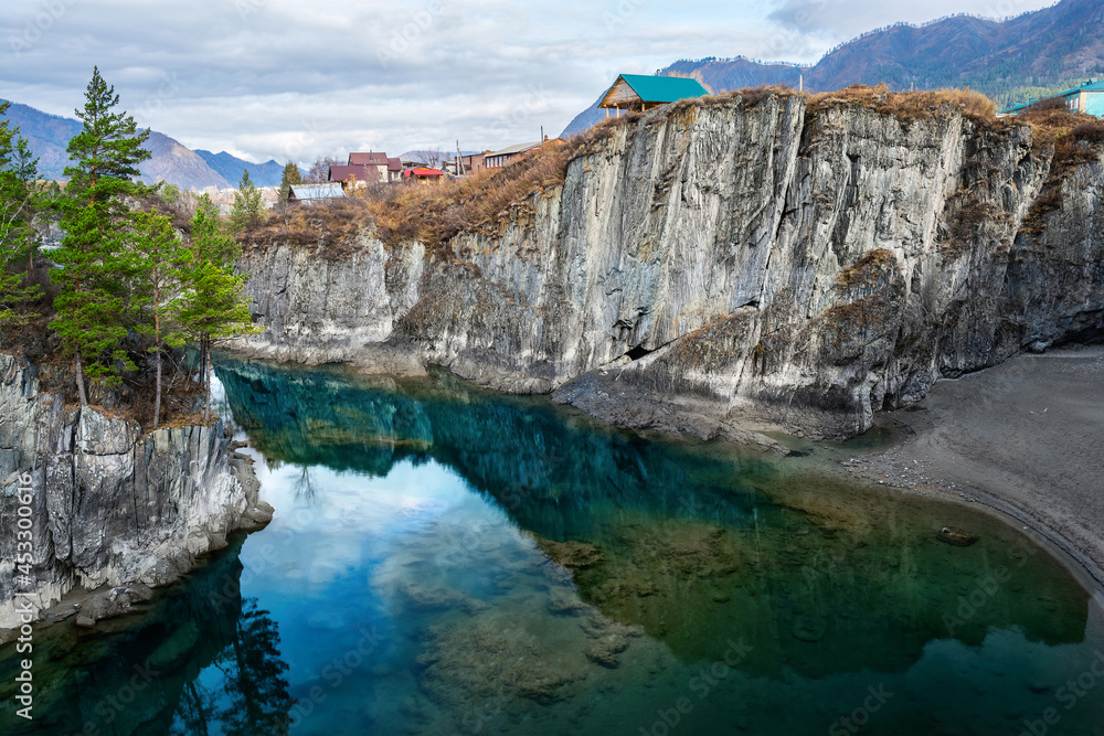 The transparent backwater of the Katun River is surrounded by rocks.
