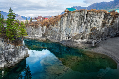 The transparent backwater of the Katun River is surrounded by rocks.