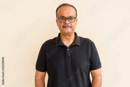 Portrait of handsome Indian man with mustache against plain wall © Ranta Images