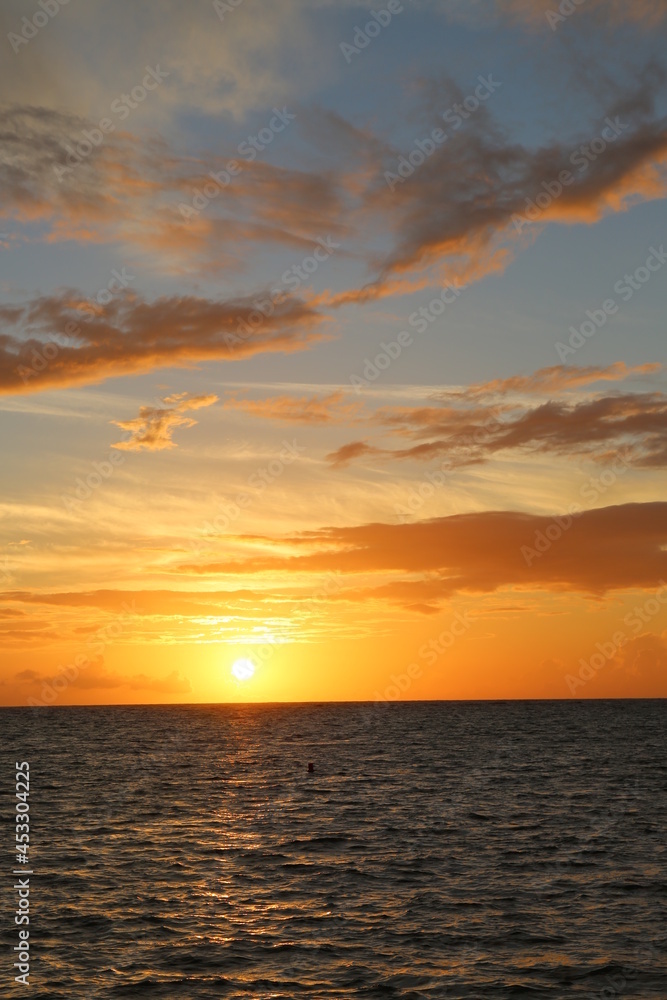 Beautiful yellow sunset over the ocean and different color sky Beautiful yellow sunset over the ocean and different color sky