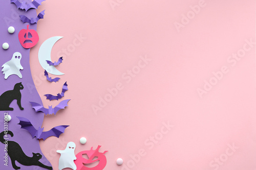 Cute Halloween background with copy-space. Kawaii black cats, vibrant purple paper bats, pink pumpkins, sweets, funny white ghosts. Top view on pink and purple paper with Crescent Moon, text space. photo