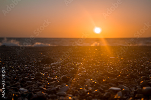Sunset at sea in summer, pebble beach. © Таня Микитюк