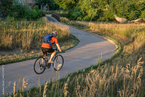 Bild auf Leinwand Senior male cyclist is commuting on a bike trail in Fort Collins in northern Col