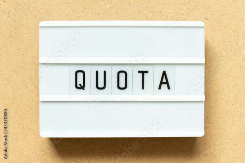Fotografia Lightbox with word quota on wood background