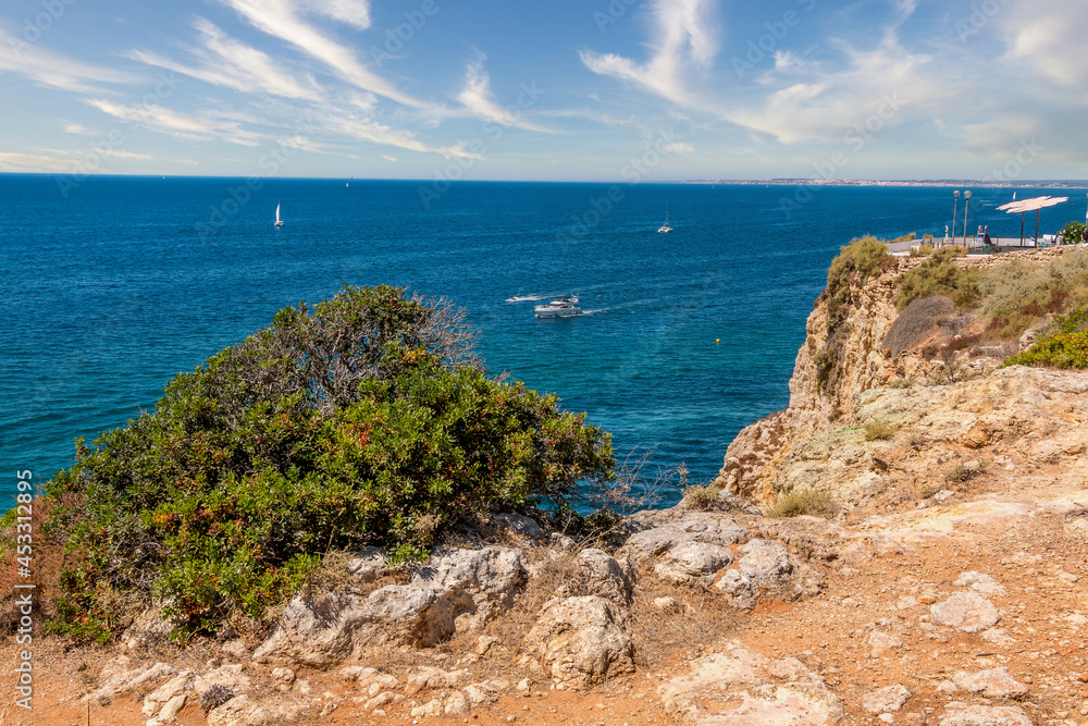 Beautiful coast line and sunny beaches in the portuguese region of Algarve. Natural caves at Carvoeiro beach, Algarve Portugal. Rock cliffs and turquoise sea water