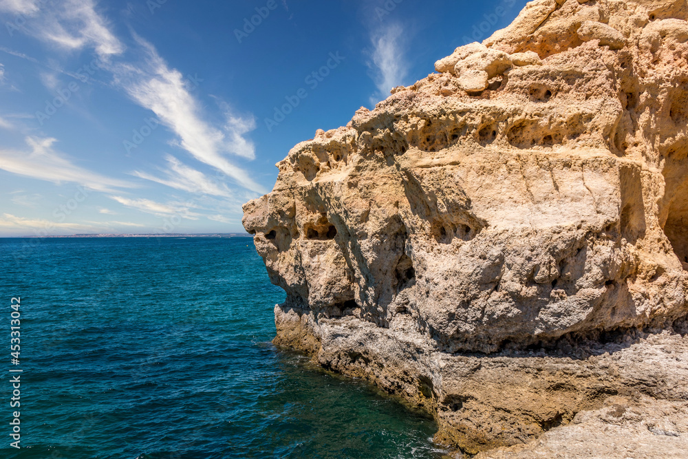 Beautiful coast line and sunny beaches in the portuguese region of Algarve. Natural caves at Carvoeiro beach, Algarve Portugal. Rock cliffs and turquoise sea water