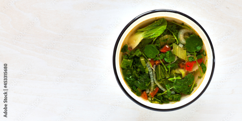 Watercress and pak choi soup broth in bowls top view. Mauritian cuisine. Watercress and pak choi soup broth in bowls top view. Mauritian cuisine.