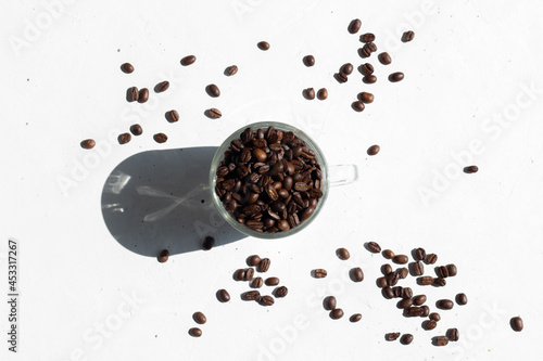 cup of coffee beans with spiled coffee beans on a white background photo