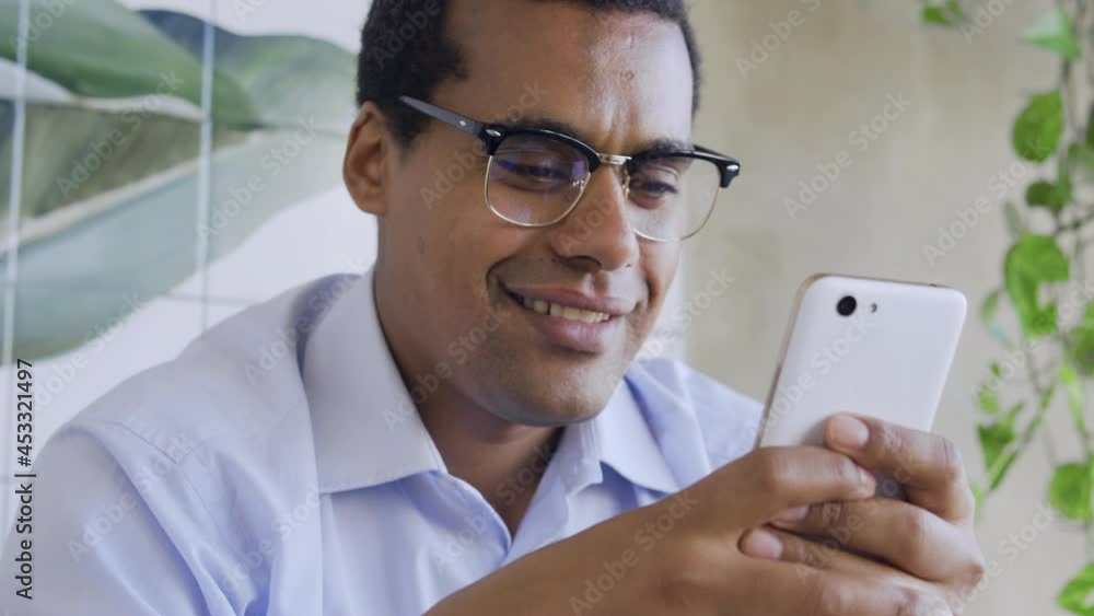 African american man smiling reading message with good news, loan approving African american man smiling reading message with good news, loan approving
