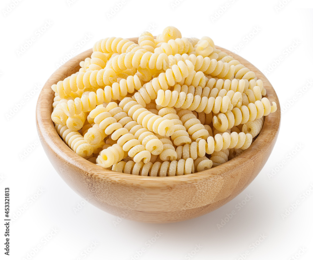 Uncooked fusilli corti bucati pasta in wooden bowl isolated on white background with clipping path