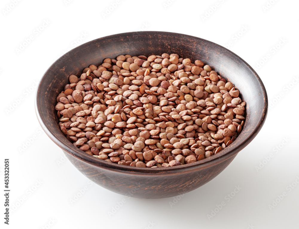 Uncooked lentils in ceramic bowl isolated on white background with clipping path
