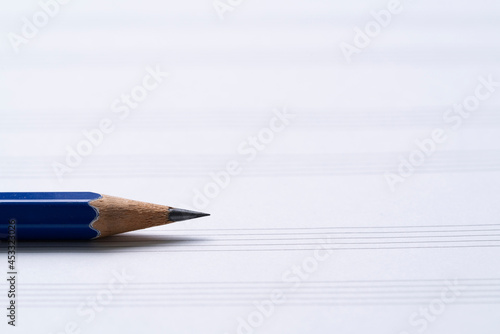 close up a pnecil and music sheet on the table background, music instrument concept photo