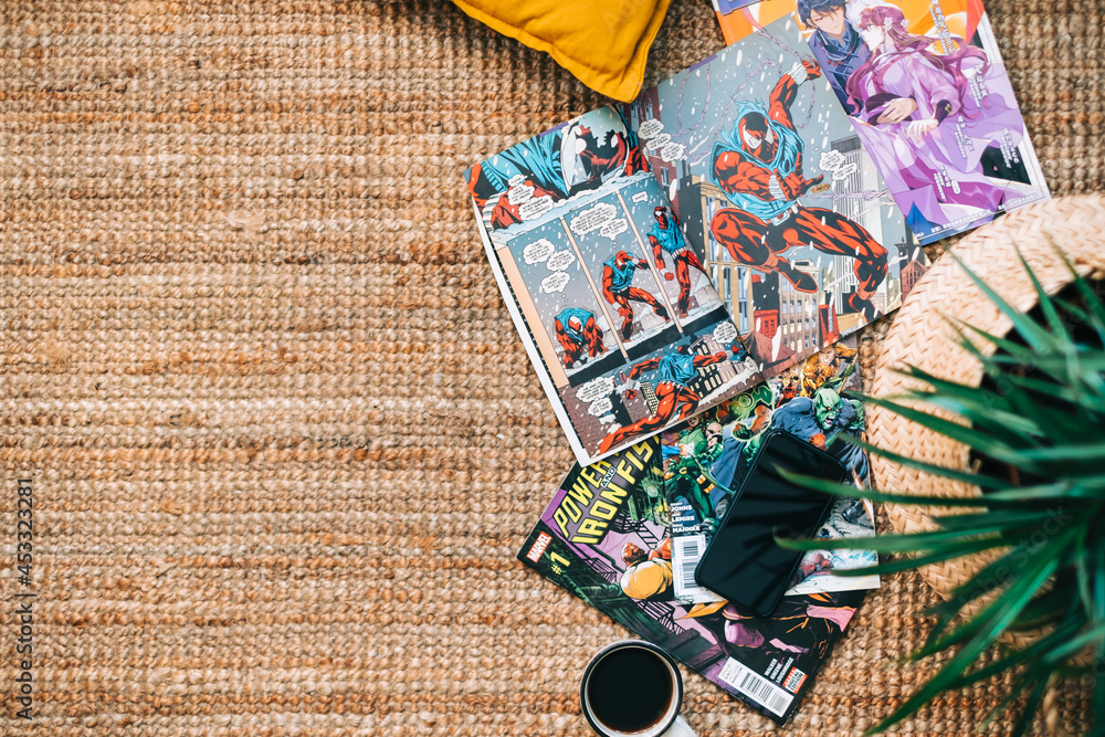 Naklejka premium Reading comic books and manga on the carpet at cozy home. Rostov-on-Don, Russia. 22 August 2021
