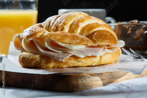 Croissant de jamón y queso con lechuga, tomate y aguacate photo