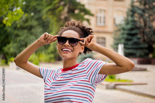 Photo of young cheerful black girl happy positive smile hands touch eyeglasses vacation weekend outdoors