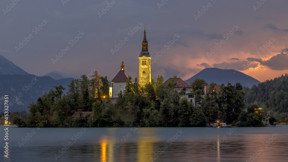 Lake bled with church under lightning in the mountains