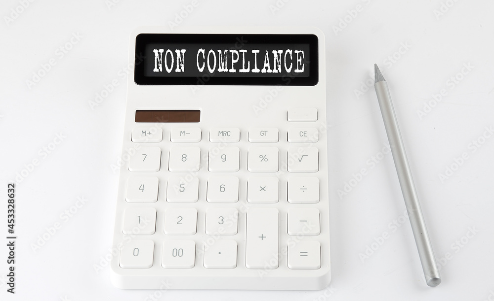 NON COMPLIANCE business text on the calculator with pencil