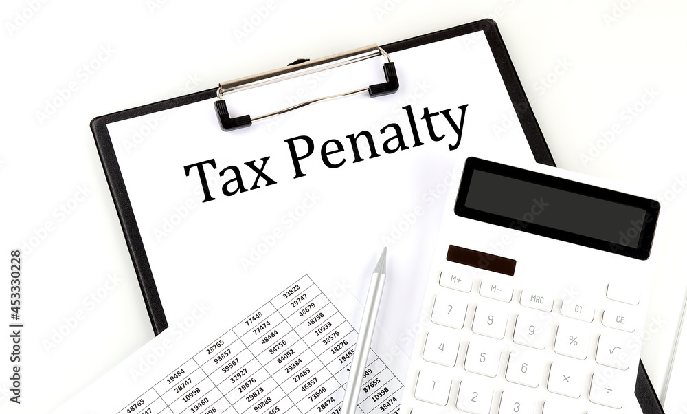 TAX PENALTY text on folder with chart and calculator on the white background TAX PENALTY text on folder with chart and calculator on the white background