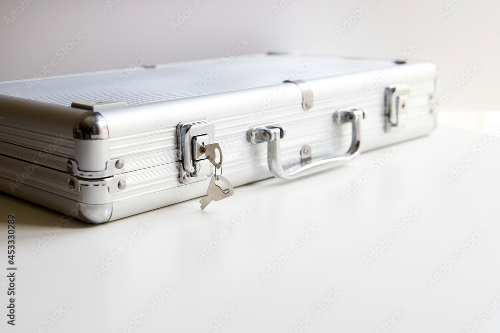 metal briefcase leaning on the table with keys in it metal briefcase leaning on the table with keys in it