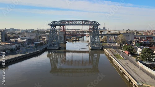 4K aerial static shot of Puente Transbordador Nicolas Avellaneda bridge with its reflection on Riachuelo Matanza river and traffics motions in the background, Buenos Aires, Argentina. photo