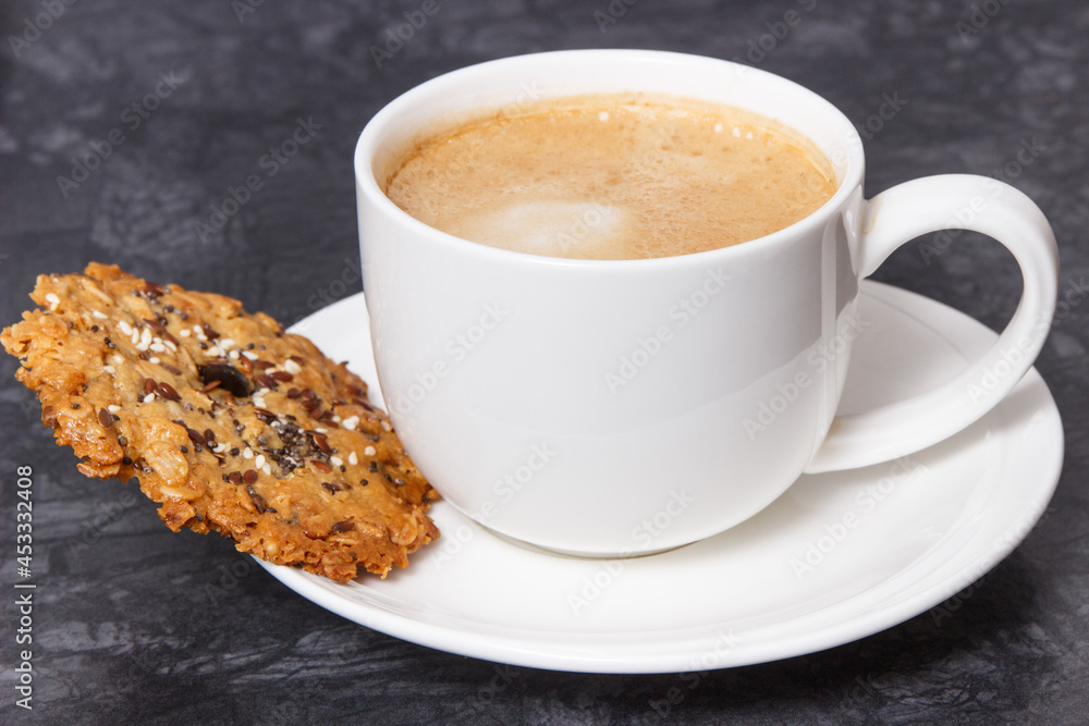 Cup of white coffee and fresh baked oatmeal cookies with honey and healthy seeds. Delicious crunchy dessert Cup of white coffee and fresh baked oatmeal cookies with honey and healthy seeds. Delicious crunchy dessert
