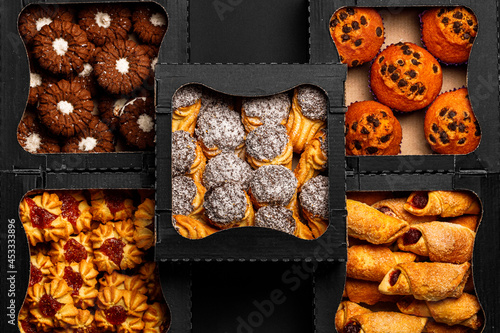 Top view different cookies in box on table top, Flat lay of cookies on black background, Prepared cookies food buffet on table for serve photo