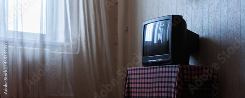 Old plastic tv stands on wooden table with checkered tablecloth