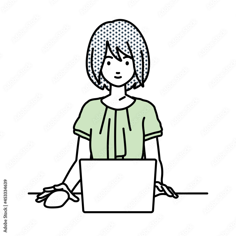 デスクで座ってPCを使っているオフィスカジュアルの女性