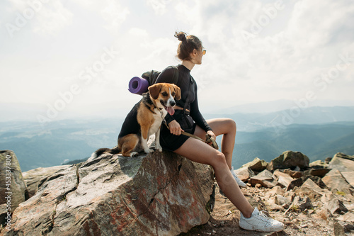 Canvas Print sporty young woman with a dog on top of the mountain