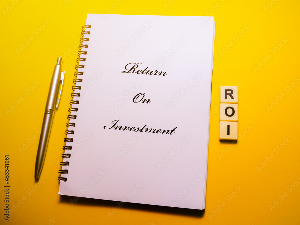 Business concept. Return on investment. Notebook, pen and square alphabets Business concept. Return on investment. Notebook, pen and square alphabets