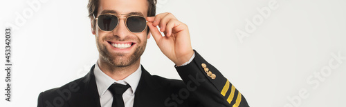 Obraz na płótnie Smiling aviator in sunglasses isolated on white, banner
