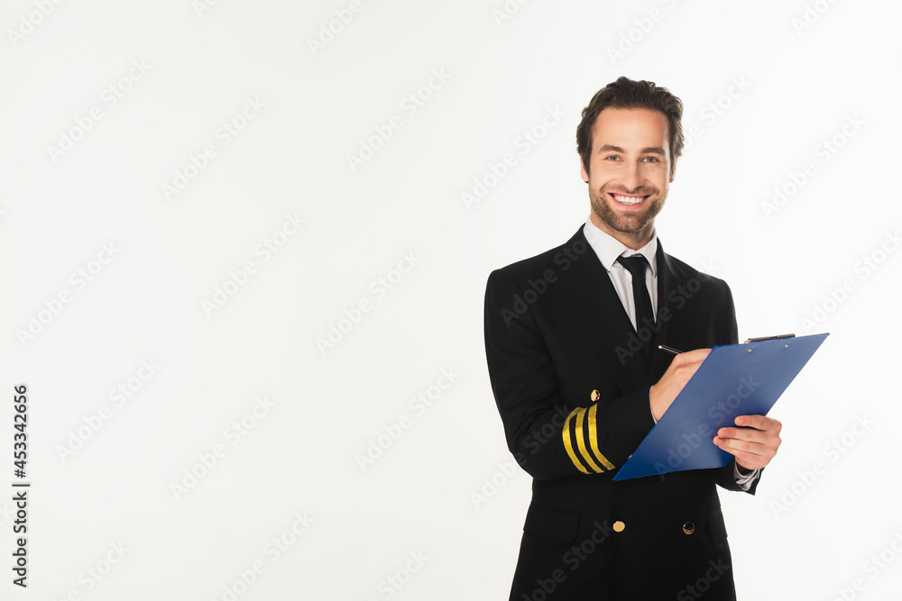 Smiling pilot writing on clipboard isolated on white Smiling pilot writing on clipboard isolated on white