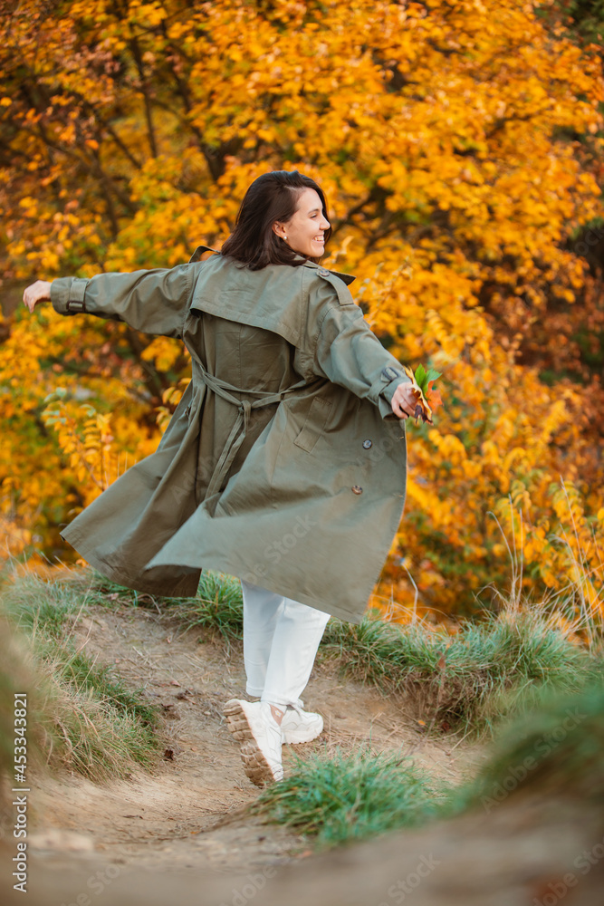 smiling woman in front of golden autumn leaves smiling woman in front of golden autumn leaves