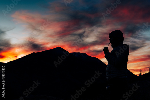 silhouette of a person on the top of the mountain