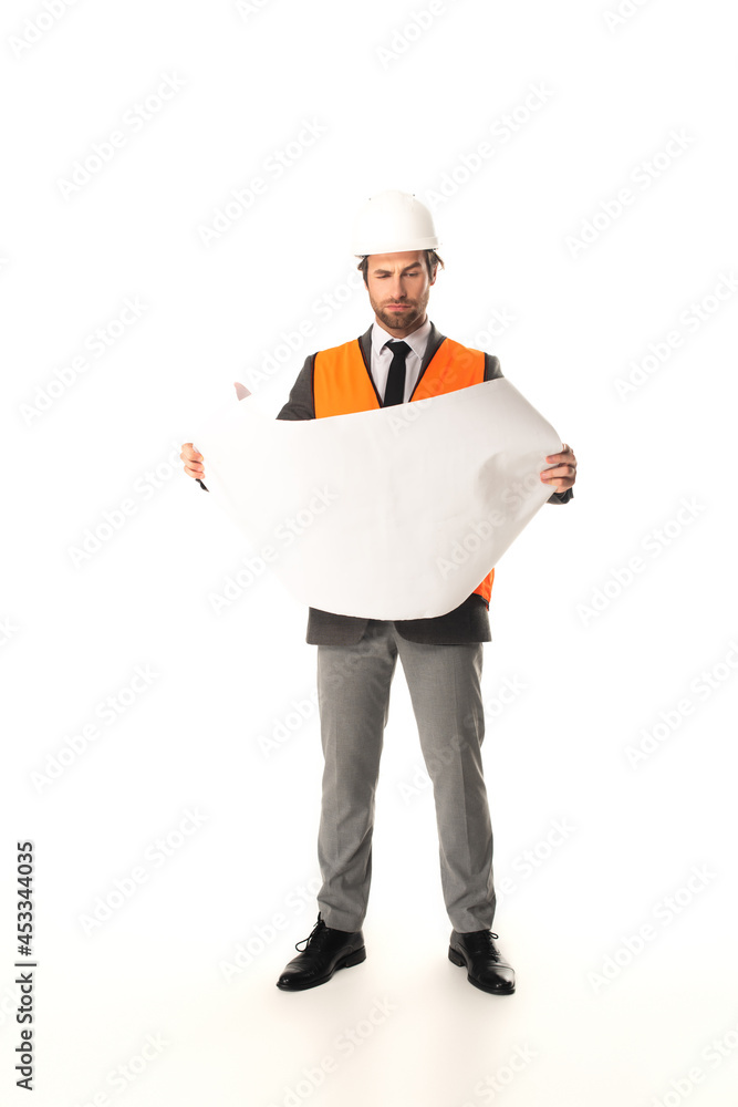 Focused engineer looking at blueprint on white background Focused engineer looking at blueprint on white background
