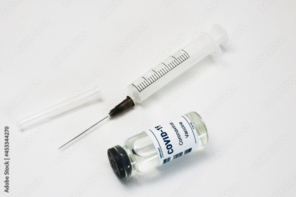 Syringe stuck in an ampoule on a white background. Syringe stuck in an ampoule on a white background.