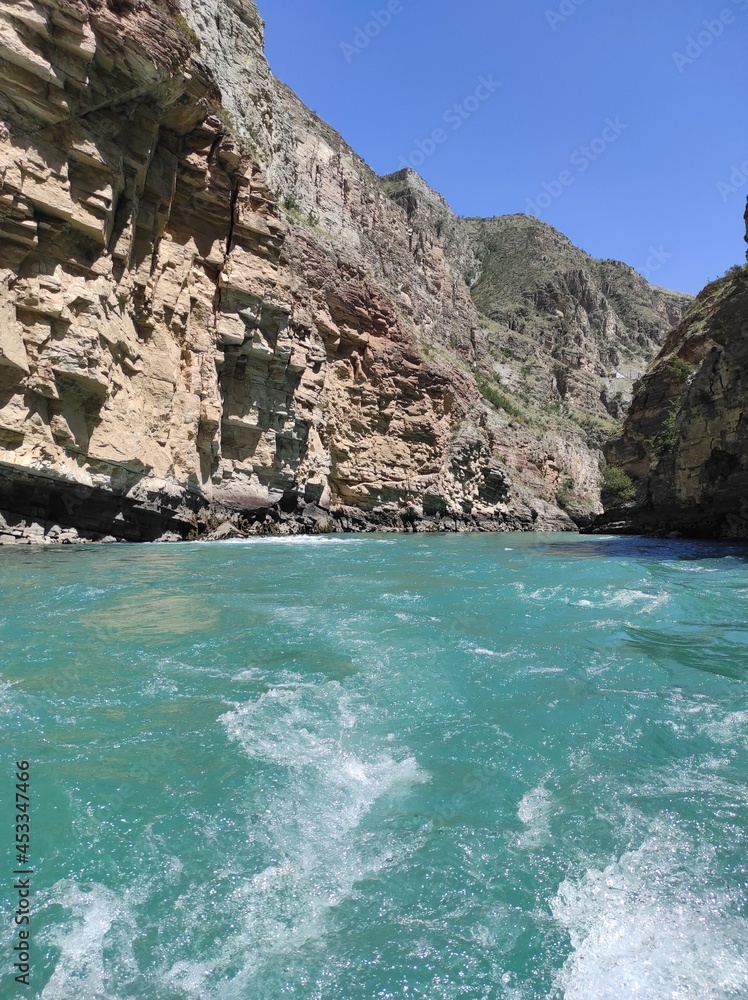 deep canyon with a blue river and beautiful mountains against the sky