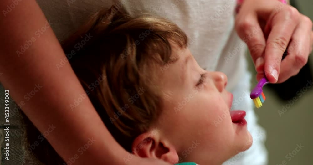 Parent brushing child tongue routine before bed Parent brushing child tongue routine before bed
