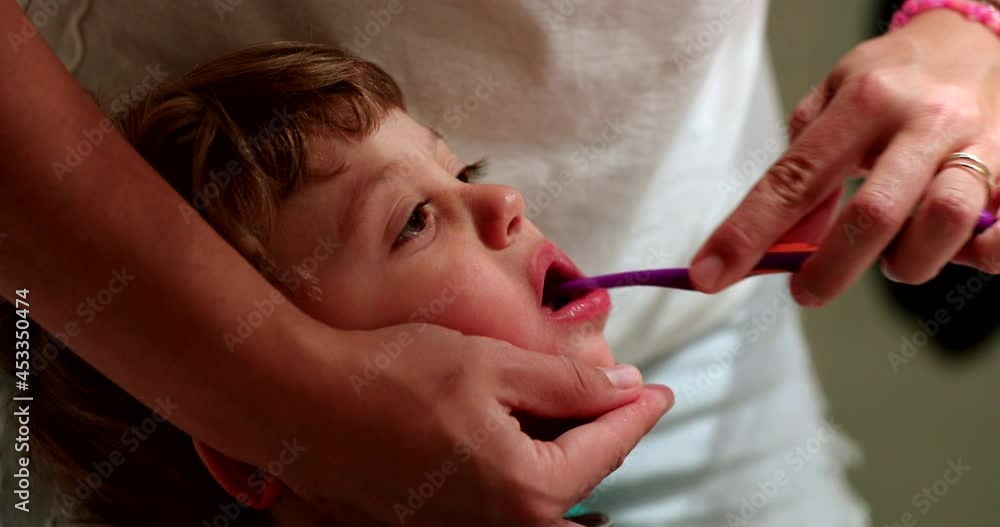 Parent brushing toddler teeth before bed. Mom brushes child teeth Parent brushing toddler teeth before bed. Mom brushes child teeth