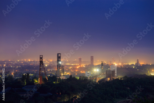 Industrial area with a large number of mines for underground mining of ore or coal. Night view of the towers of the mine shafts.