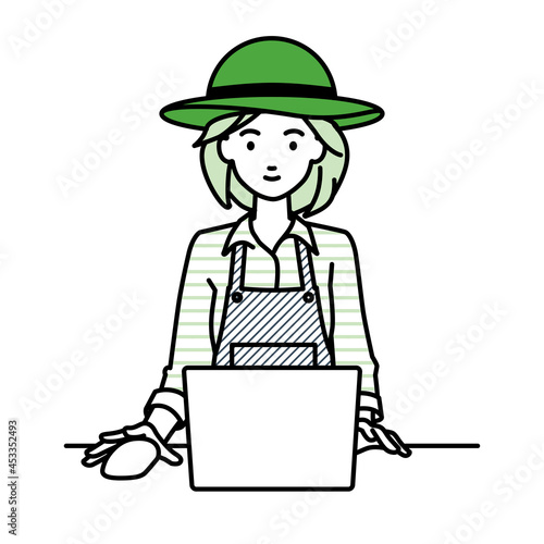デスクで座ってPCを使っている農家の女性
