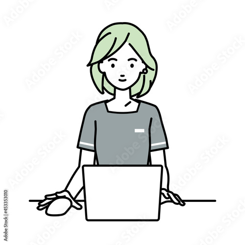 デスクで座ってPCを使っているエステ店員の女性