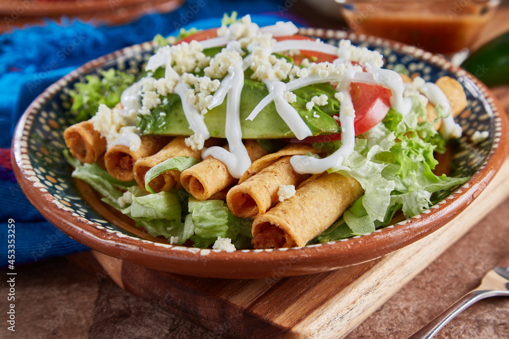 Flautas de pollo con lechuga, tomate, crema y queso Stock Photo Adobe