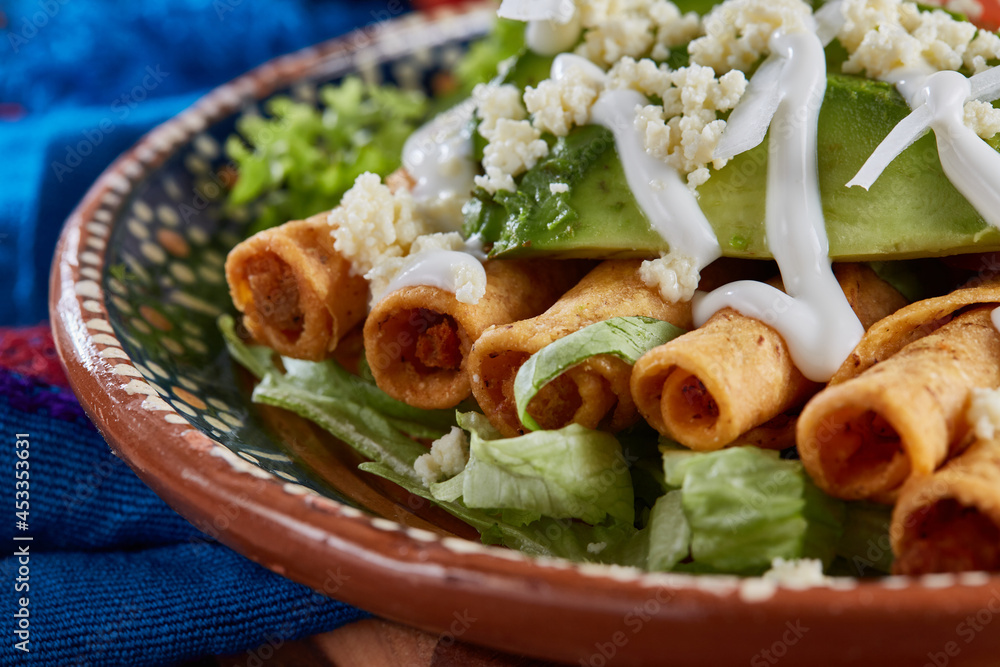 Flautas de pollo con lechuga, tomate, crema y queso Stock Photo Adobe