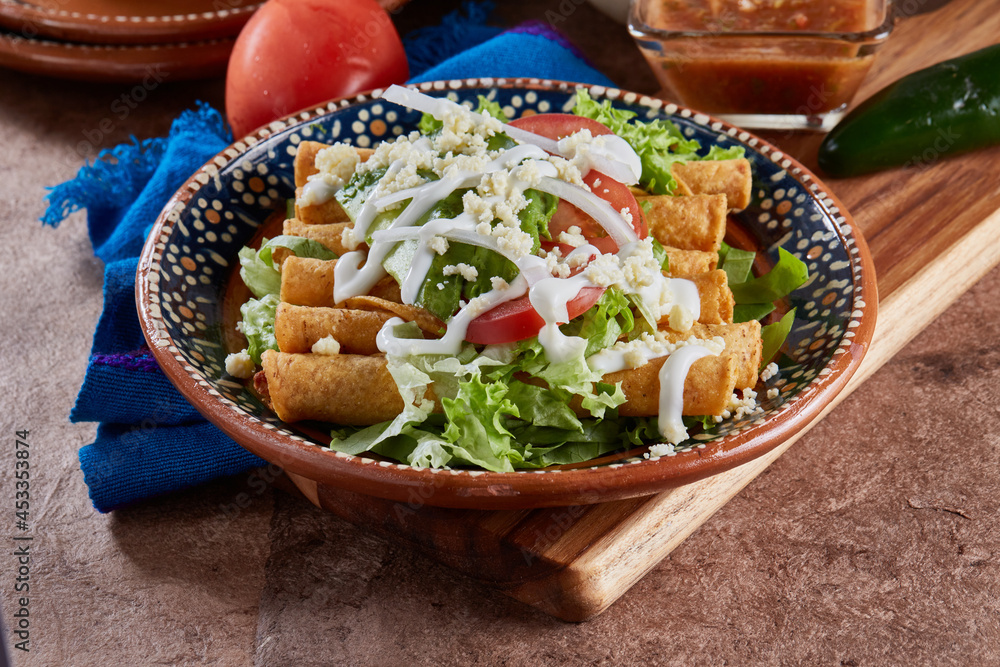 Flautas de pollo con lechuga, tomate, crema y queso Stock Photo Adobe