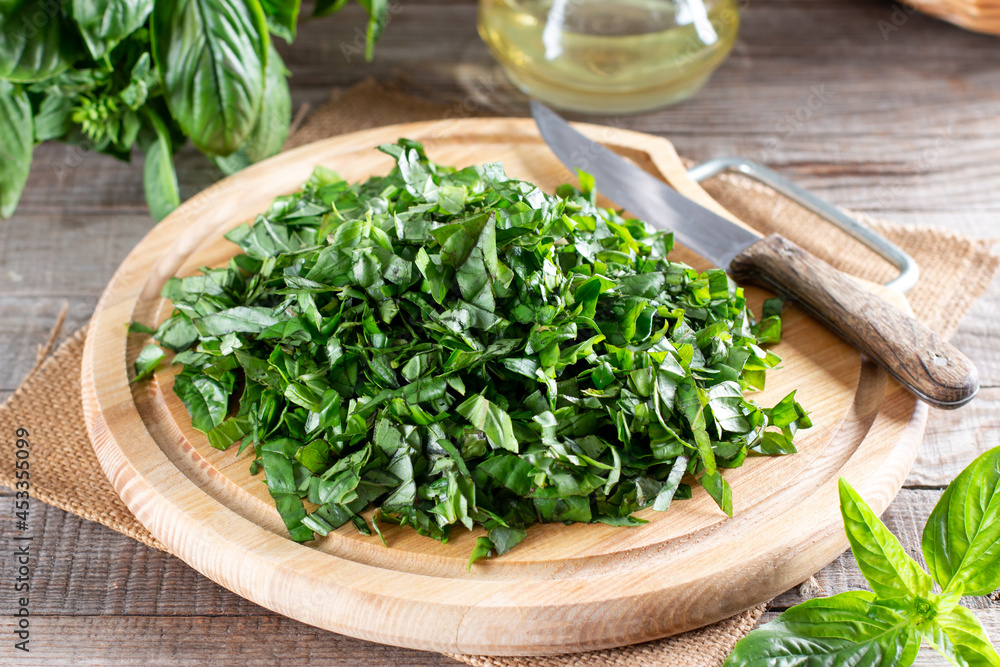 Sliced basil on a cutting board on a table. Frozen vegetables. Concept of eating. Sliced basil on a cutting board on a table. Frozen vegetables. Concept of eating.