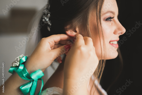 Portrait of beautiful bride with fashion veil at wedding morning