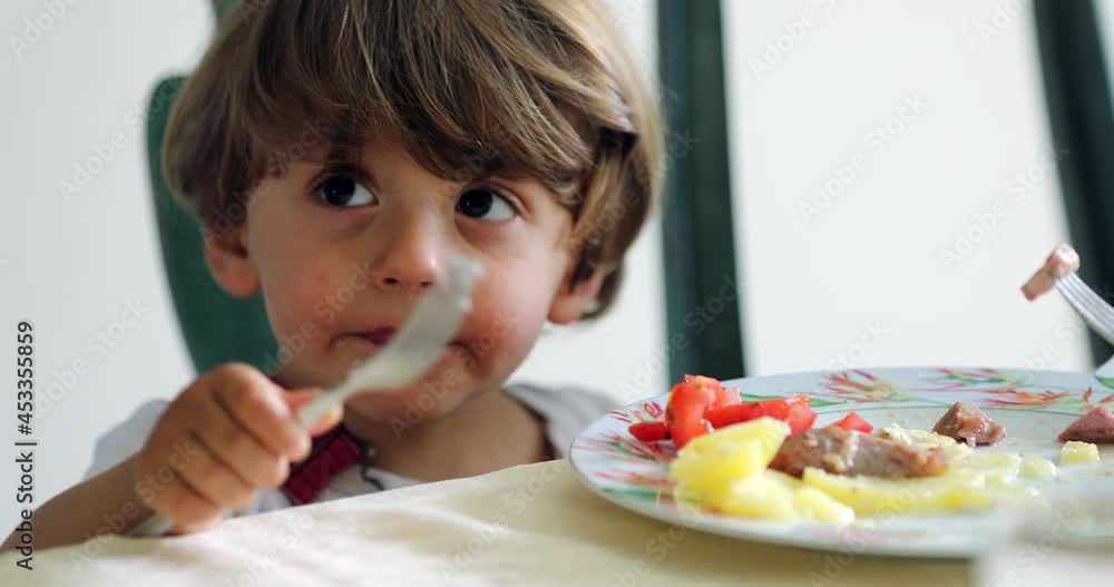 Toddler kid eating lunch sititng at table Toddler kid eating lunch sititng at table