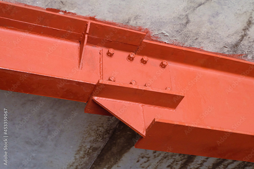 Bolted connection of steel beams. Metal construction covered primer red