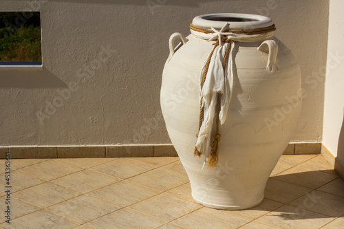 White amphora decorated with fabric. Greek theme. photo